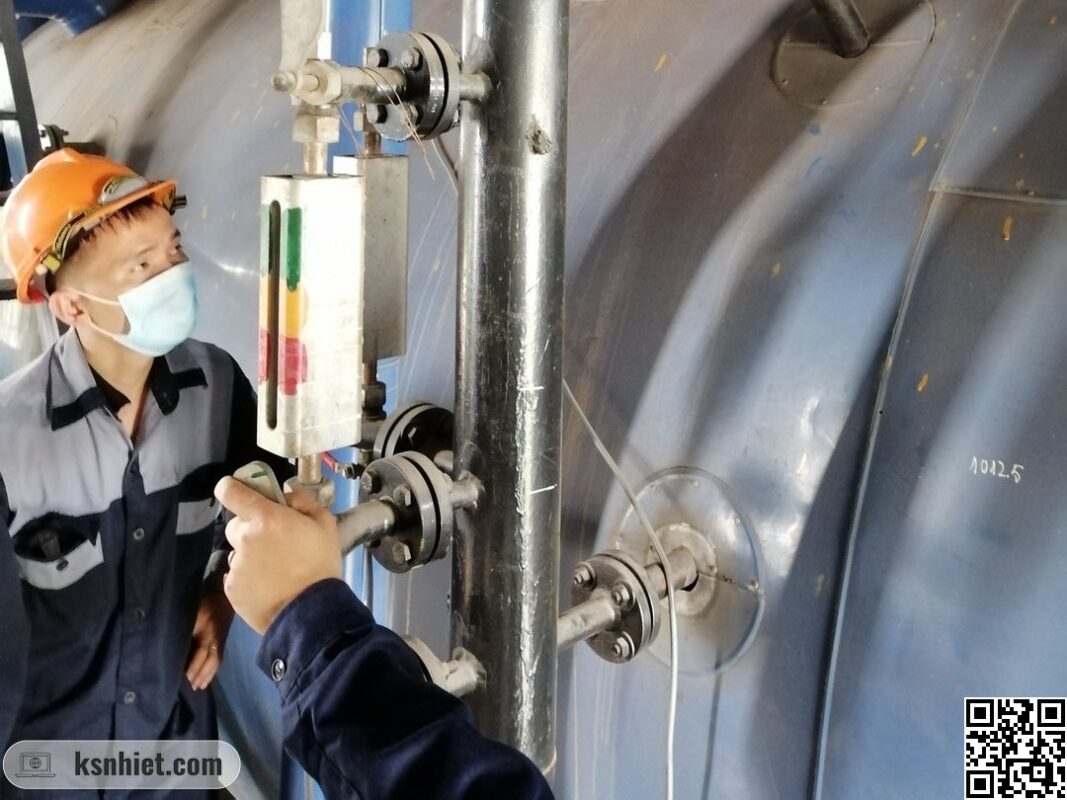 Làm Thế Nào Để Đảm Bảo An Toàn Khi Vận Hành Lò Hơi? - Kinh Nghiệm Từ Chuyên Gia 2 Người vận hành đang kiểm tra và vệ sinh kính thuỷ lò hơi