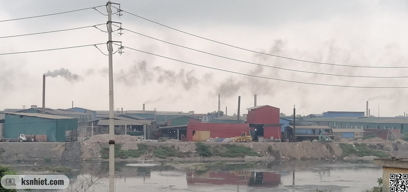 Xu Hướng Lò Hơi 2026-2030: Chuyển Đổi Để Tối Ưu Hiệu Suất và Bền Vững 4 Hình ảnh tại một khu làng nghề với các ống khói nhả khói đen lên bầu trời