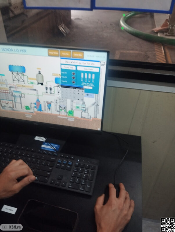Hệ thống PLC–HMI: Vai trò của trực quan hóa thông số kỹ thuật và quản lý dữ liệu vận hành thời gian thực 6 Công nhân đang vận hành lò hơi thông qua màn hình SCADA