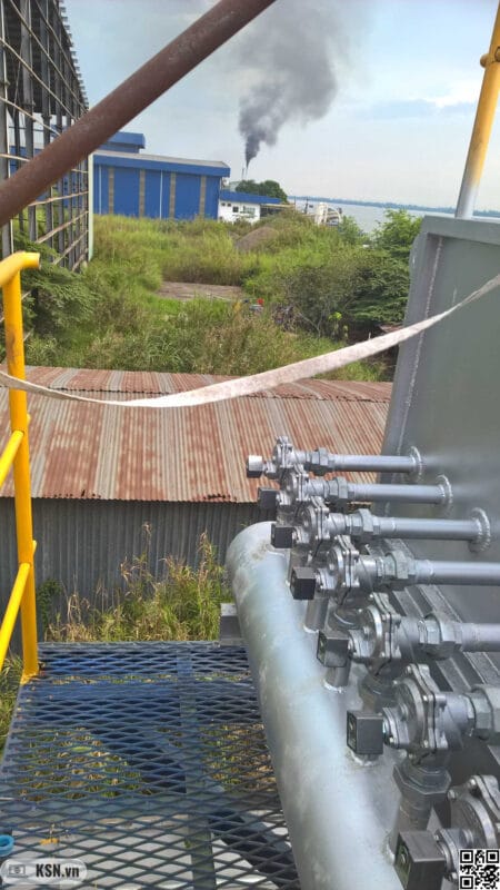 Tại sao nồng độ Oxy dư tham chiếu cho lò hơi Biomass lại là 6%? 3 Ảnh chụp từ vị trí bộ lọc bụi túi vải và phía xa là lò hơi đang phát thải khói đen